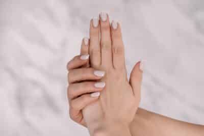 Beautiful female hands with french manicure on nails. Soft skin, skincare, beauty treatment concept.